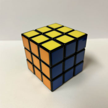 A Rubik’s Cube is a small, colorful 3D puzzle made up of rotating rows and columns of cubes on a six-sided surface, designed to align all faces by color through strategic twists and turns.
